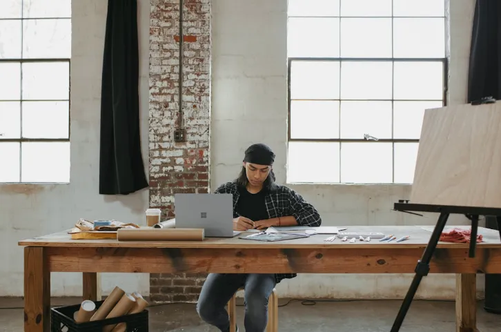 A man working remotely on his laptop, using faxing software seamlessly integrating with popular cloud storage services, highlighting its compatibility and ease of use.